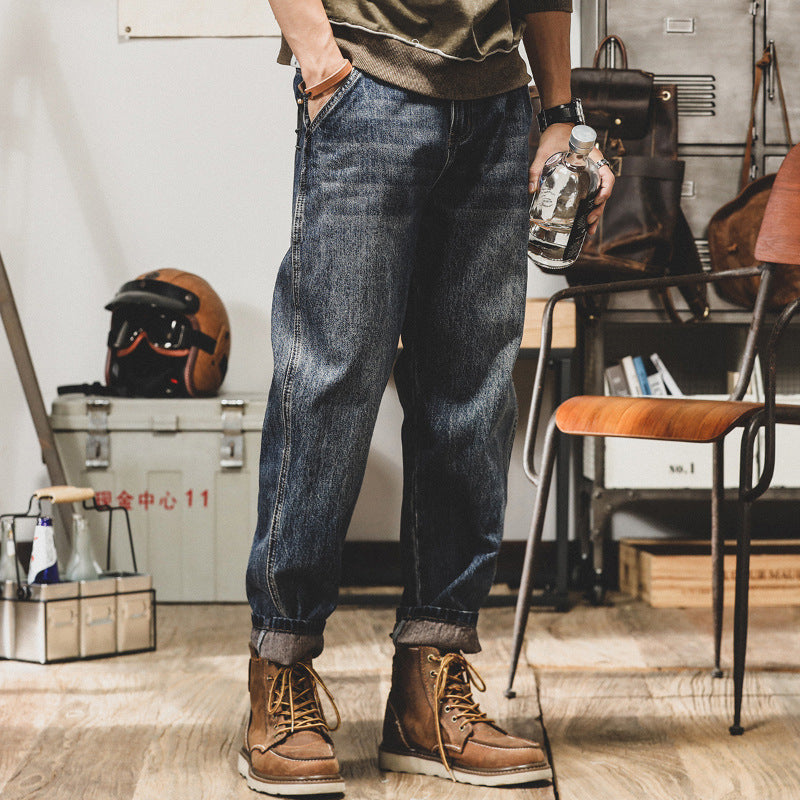 Person wearing blue jeans and brown boots in a workshop setting